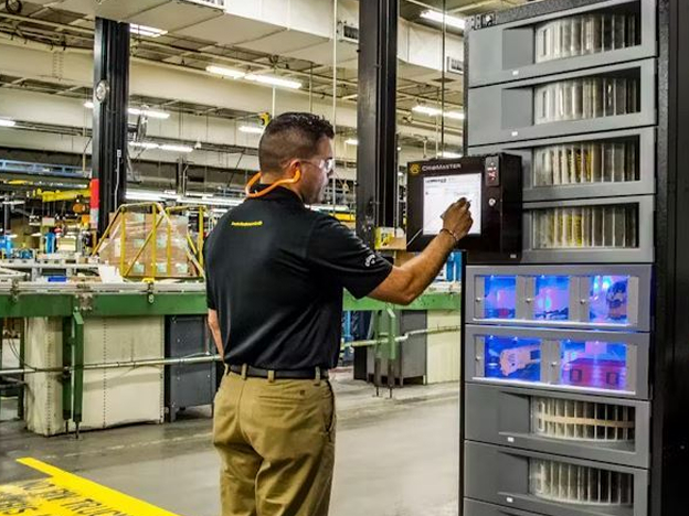A man in a warehouse checking inventory on a screen