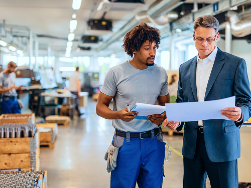 Two men in an office looking at plans