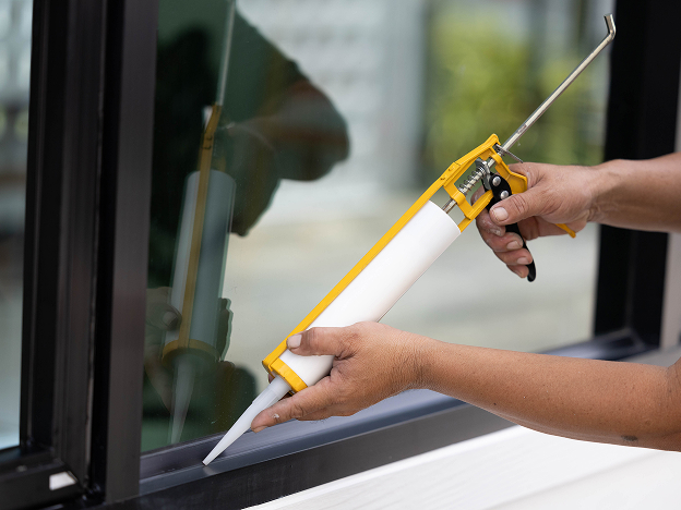 A demonstration of adhesive being applied to an outdoor window