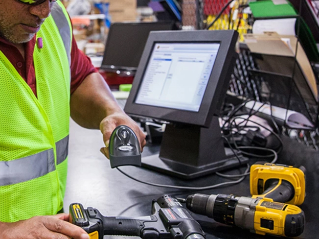 A man wearing a safety vest scanning power tools